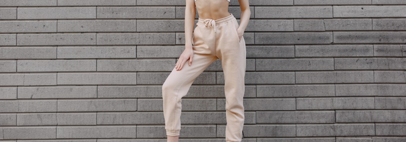 Kobieta na zdjęciu wie, jakie buty do spodni dresowych ubrać.