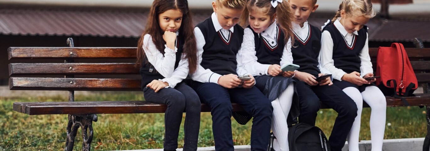 Jakie ubrania do szkoły ubrać? Na zdjęciu dzieci w szkole w mundurkach.